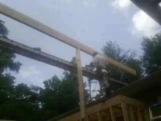 Carpenter setting a ridge beam over a new addition frame — Ice Dam Removal by Roofing Brothers in Mount Prospect