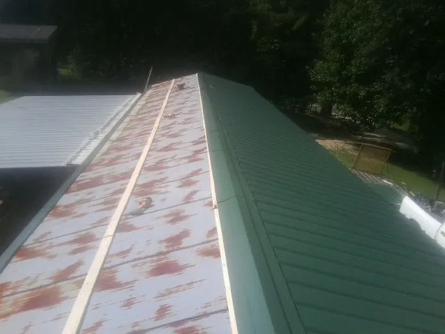 Old rusted panels beside newly installed green metal roofing — Wind Damage Roof Repair by Roofing Brothers in Mount Prospect