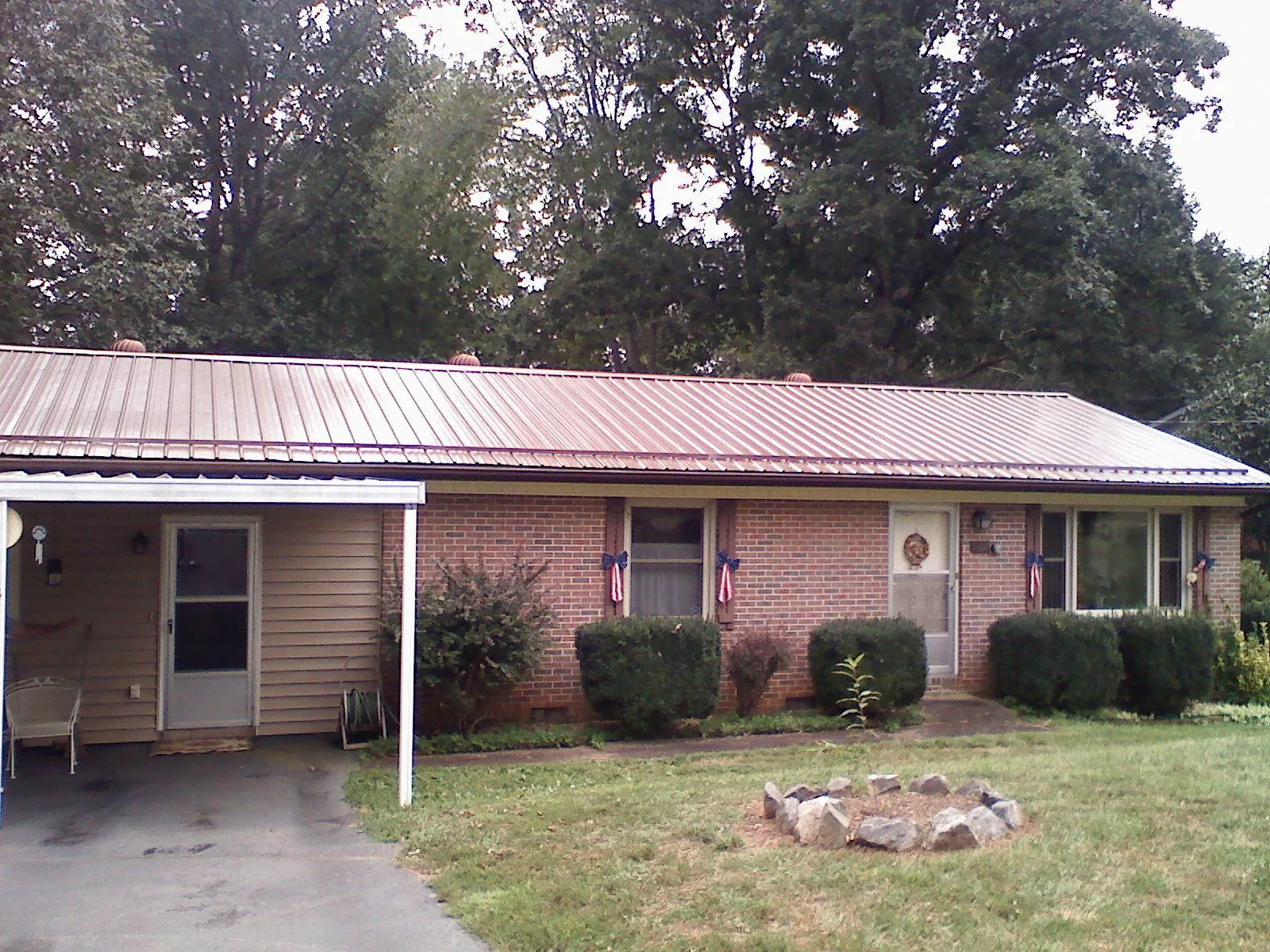 Bronze metal roof and carport on a brick ranch home — Roof Repair work by our crew in Mount Prospect